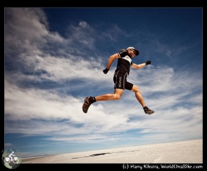 Harry jumps in his Santos outfit, for joy on the Salar de Uyuni, on WorldOnaBike.com, from Alaska to Ushuaia on a bicycle